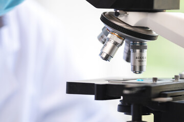 professional research scientist using microscope in science chemistry laboratory, medical technology for biology or microbiology medicine discovery, scientific equipment for experiment in hospital lab