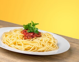 Tasty noodles dish on the plate on the desk.