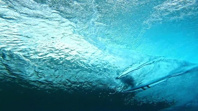 Surfer surfing big tube barrel wave. crystal clear Tahiti ocean on a sunny day. Teahupoo famous destination in French Polynesia. Adventure water sports travel. slow motion.