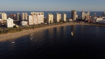 Fototapeta na wymiar Punta del Este beach with waterfront buildings at sunrise, Uruguay. Aerial