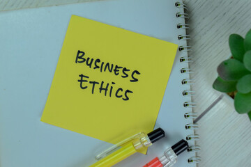 Concept of Business Ethics write on a book isolated on Wooden Table.