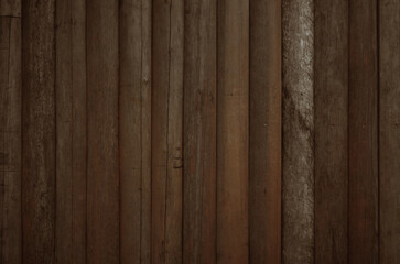 Dark brown log wall texture background. Fence lined with old logs.