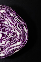 Purple cabbage cut ob a black board