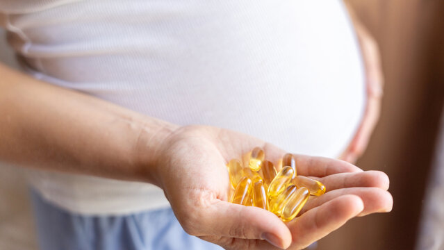 Prenatal Vitamins Pill. Happy Smiling Woman Taking Pill With Supplement Vitamin Omega 3. Vitamin D, E, A Fish Oil Capsules.