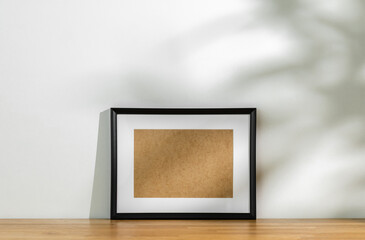 Style picture frame still life put on the wooden table. Blank space empty picture frame with mockup. Shot in studio with natural light. Template background interior design and decoration.