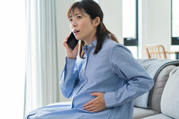 自宅で電話をかける日本人妊婦