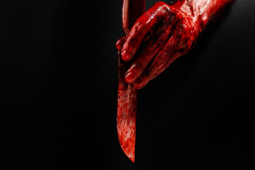 Man holding knife with bloody hand on black background.  © Михаил Решетников
