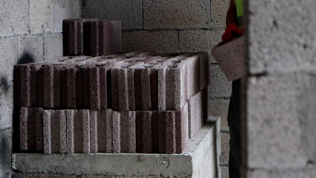 Construction workers carrying building bricks at construction site. Preparing concrete blocks for work, 4k