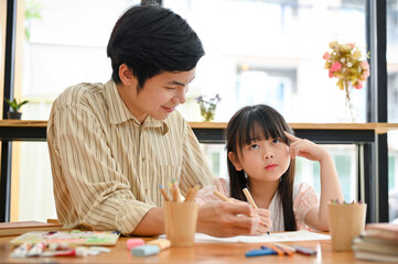 Smart and cute young Asian girl studying and practicing painting art with her private art tutor
