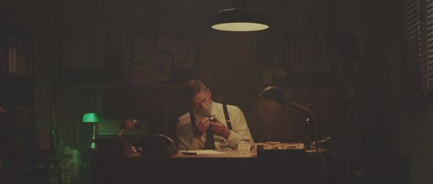 Man smoking pipe in office in evening. Retro style detective using deduction for solving challenging cases.