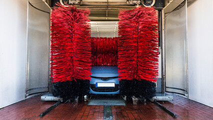 Car washing machine. Auto brush washer clean blue car on automatic carwash station. Automated car...