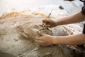 Artists are creating works of art by sculpting clay into shapes.