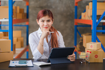 Starting Small business entrepreneur SME freelance,Portrait young woman working at home office, BOX,smartphone,laptop, online, marketing, packaging, delivery, SME, e-commerce concept