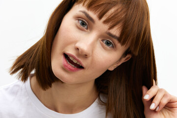 Naklejka premium a close, horizontal portrait of a happy, beautiful, attractive red-haired woman playfully pulling back a lock of her well-groomed hair