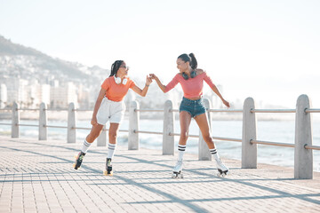 Black women, fist bump and roller skating happy friends by the sea, ocean or shore outdoors....