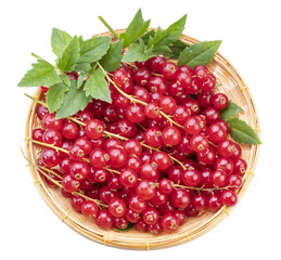 Red currant in bamboo basket on wooden background, Red currant berries with leaf on wooden table.