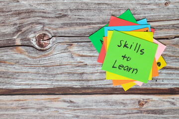 Learn new skills for self improvement and personal development concept. Green sticky note reminder...