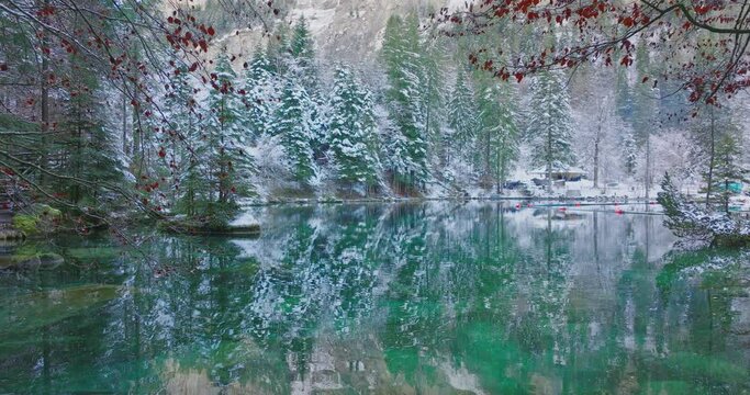 Scenic view of famous mountain lake Blausee located in the Kander valley above Kandergrund in the Jungfrau region, Switzerland. Romantic blue lake nature park in the Bernese Alps during winter season.