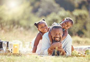 Happy father and children on a family picnic on nature field in summer together. Portrait man and...