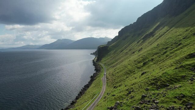 Aerial view of a car driving along the coastline on Isle of Mull, Scotland, United Kingdom.