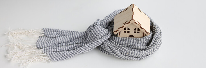 Small wooden house is wrapped in scarf closeup