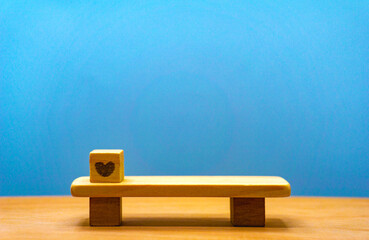木のベンチの上にハートがあるミニチュアで愛に関する見出しの素材