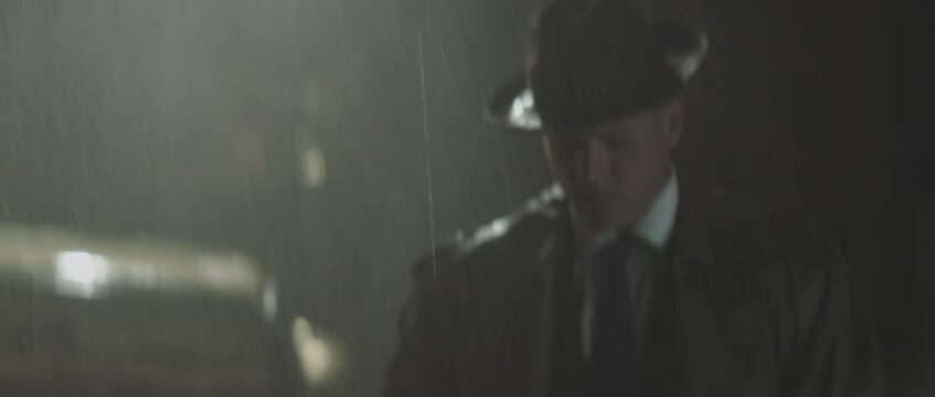 Private Detective getting out of car, looking around and walking on rainy street. Retro style detective using deduction for solving challenging cases.