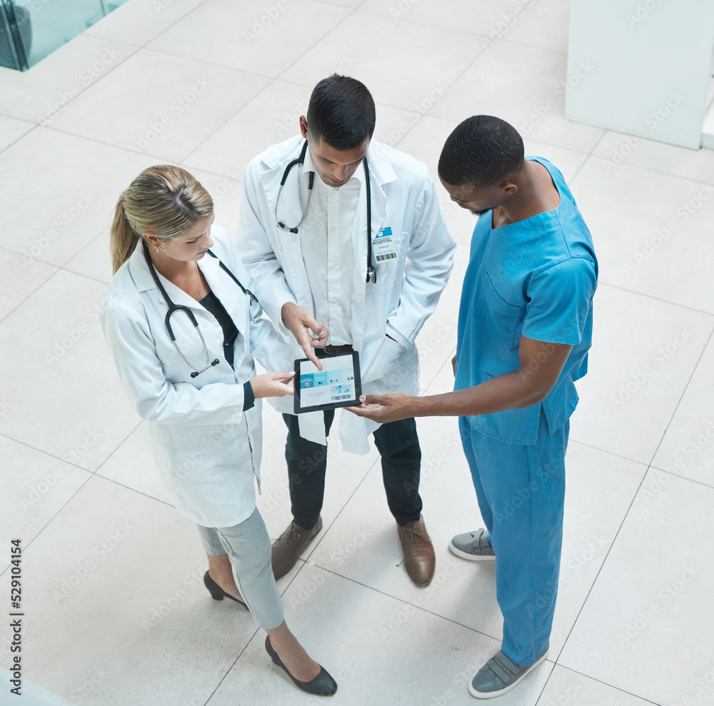 Poster group of doctors working on digital tablet while standing in the hospital hallway and talking. top v