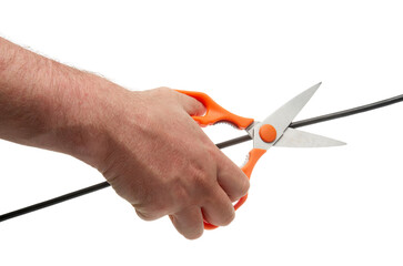 Human hand with scissors cuts a black wire