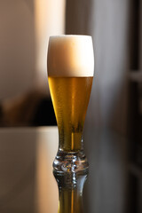 Cold beer on reflective glass table