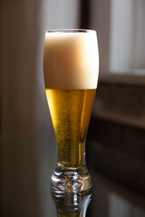 Cold beer on reflective glass table