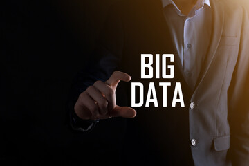 Businessman in a suit on a dark background holds the inscription BIG DATA. Storage Network Online...