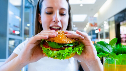 Veggie sandwich healthy vegan burger. Cute cheerful girl eating vegetarian hamburger with salad, avocado, vegetable. Hamburger vegan healthy diet food.