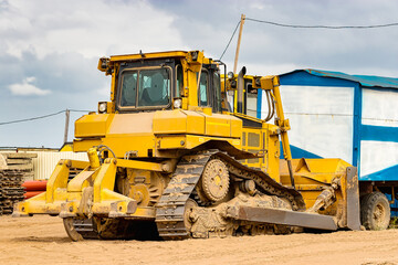 Powerful crawler bulldozer close-up at the construction site. Construction equipment for moving large volumes of soil. Modern construction machine. Road building machine.