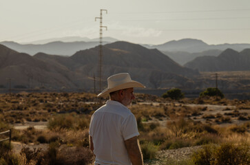 Fototapeta na wymiar Adult man in cowboy hat in desert. Almeria, Spain