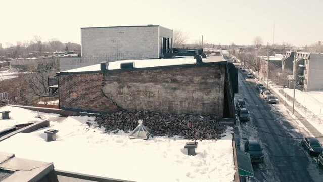 Broken, fallen brick wall on roof. Drone pan left with wall point of view. 4k Mavic 3. UHD. Winter scene.