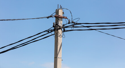 Electric cable on a pole against the sky