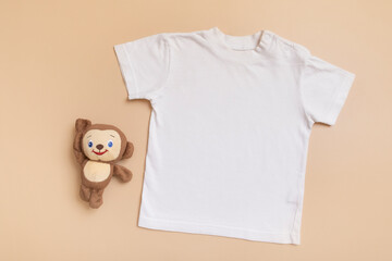 White baby t-shirt top view. Mock-up for logo, text or design on beige background. Flat lay child...