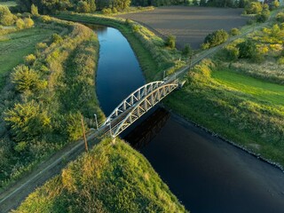 Fototapeta premium Old steel tram bridge over the Ner River in the city of Lutomiersk, Poland.
