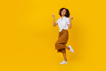 Fototapeta na wymiar Full length photo of excited charming person hands fingers show v-sign empty space isolated on yellow color background