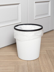 White plastic bucket with bag. Cleanliness in the house. Trash can for kitchen, living room,...
