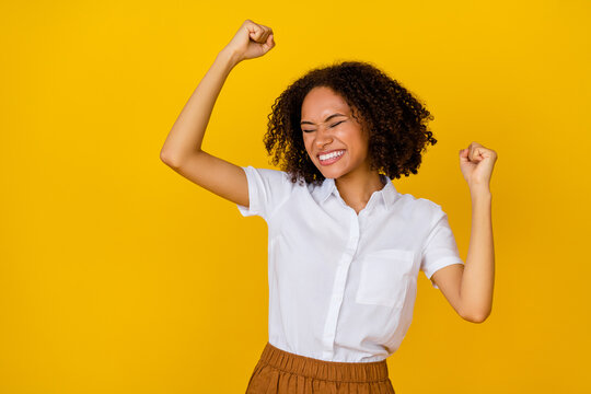 Photo of overjoyed lady raise arm fists yeap waited discounts shopping black friday empty space for ad isolated on yellow color background