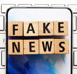 FAKE NEWS words arranged from wooden letters.