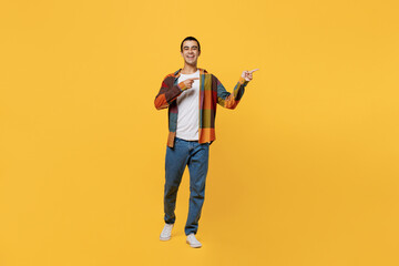 Full body young fun middle eastern man 20s wear casual shirt white t-shirt pointing indicate on workspace area copy space mock up isolated on plain yellow background studio People lifestyle concept