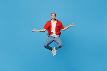 Fototapeta na wymiar Full body young man of African American ethnicity wear red shirt jump high hold spread hands in yoga om aum gesture relax meditate try to calm down isolated on plain pastel light blue cyan background.