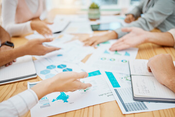 Marketing and advertising team planning strategy with paperwork or document in a meeting in an office. Teamwork and collaboration in a business meeting discussing profit and data graphs on paper