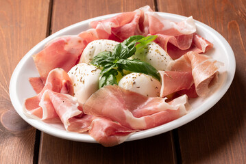 Piatto con prosciutto e mozzarella di bufala, deliziosi antipasti italiani 
