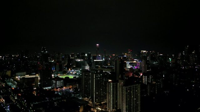 4K Cinematic urban drone footage of an aerial view of buildings and skyscrapers in the middle of downtown Bangkok, Thailand at night