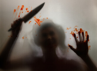 Woman killer with a knife in her hand and blood. Creepy background