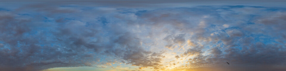 Panorama of a dark blue sunset sky with golden Cumulus clouds. Seamless hdr 360 panorama in...